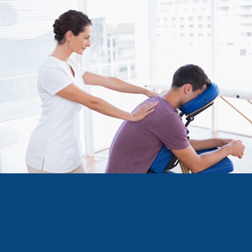 Physiotherapist giving a back massage treatment to a seated patient